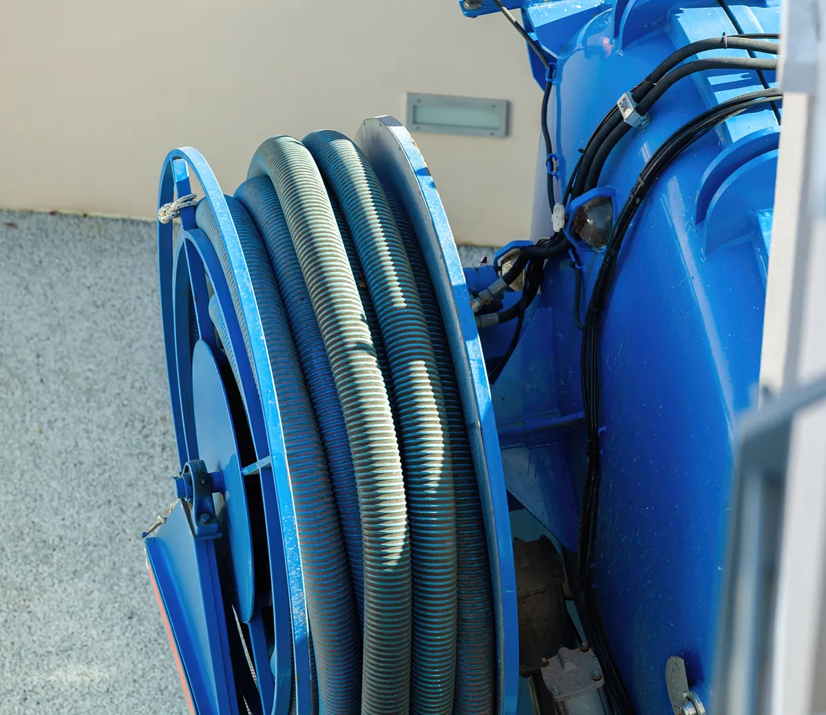Hochdruckspülung – Schlauchtrommel am Kanalreinigungsfahrzeug Blaue Schlauchtrommel mit Hochdruckschläuchen an einem Kanalreinigungsfahrzeug